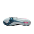 Bottom view of a Nike soccer cleat's translucent white and teal soleplate, featuring traction studs and a pink swoosh on the heel.