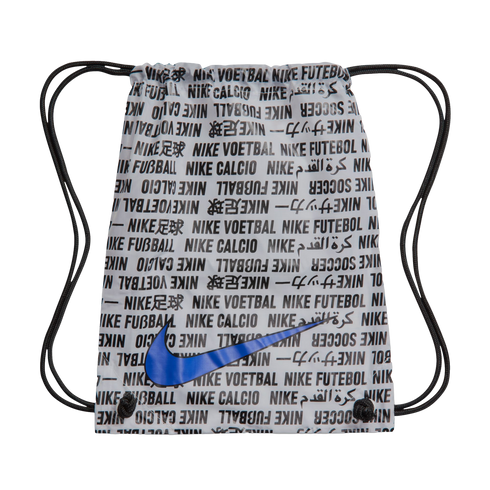 White Nike drawstring bag with repeating multilingual "Nike Soccer" text in black and a large blue swoosh centered on the front.
