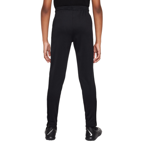 Back view of a person wearing black athletic pants and Nike soccer cleats against a white background.