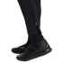 Close-up of a person wearing all-black Nike athletic gear, including Phantom GT turf shoes, socks, and tapered pants with ankle zippers.