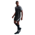 A man poses in a grey and black Nike soccer kit, featuring a short-sleeve jersey, matching shorts, and black cleats, set against a solid black background.