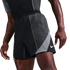 Close-up of a person wearing black Nike athletic shorts with grey mesh panels and a white swoosh logo against a solid black background.