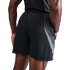 Rear view of a person wearing black athletic shorts with grey mesh side panels and a matching black tank top against a black background.
