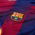 Close-up of a red and blue striped FC Barcelona football jersey featuring the club's crest.