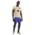 A man modeling a gold FC Barcelona x Kobe Bryant jersey with purple shorts and black socks against a black background.