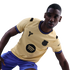 A man in a tan FC Barcelona football jersey featuring Kobe Bryant’s "Sheath" logo and a Spotify logo, wearing blue shorts against a black background.