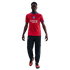 A man modeling a red Paris Saint-Germain soccer jersey, black track pants, and orange sneakers against a black background.