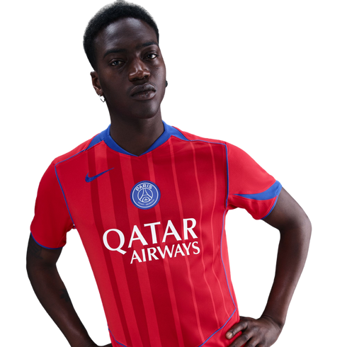 A young Black man posing in a red striped Paris Saint-Germain jersey with 'Qatar Airways' sponsor text and blue accents, set against a black background.