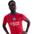 A young Black man posing in a red striped Paris Saint-Germain jersey with 'Qatar Airways' sponsor text and blue accents, set against a black background.