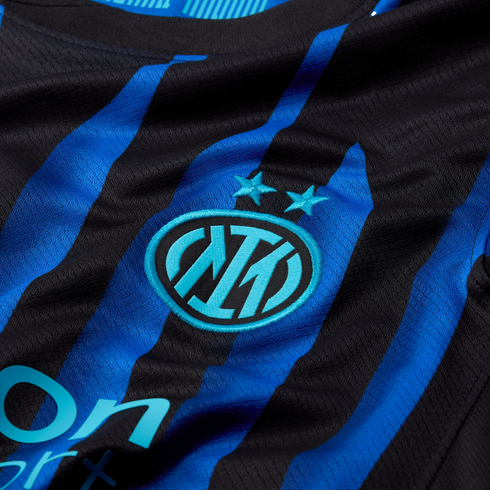 Close-up of a blue and black striped football jersey with the Inter Milan logo and two stars embroidered in light blue.