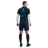 Back view of a man in a black and blue patterned football jersey, navy shorts, and black socks against a white background.