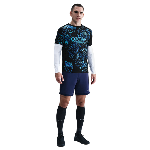 Male athlete standing in a black and blue Inter Milan kit, white compression sleeves, navy shorts, and black socks against a plain white background.
