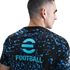 Rear view of a man wearing a black t-shirt with a blue abstract print and the light blue eFootball logo on the back. He faces right against a white background.