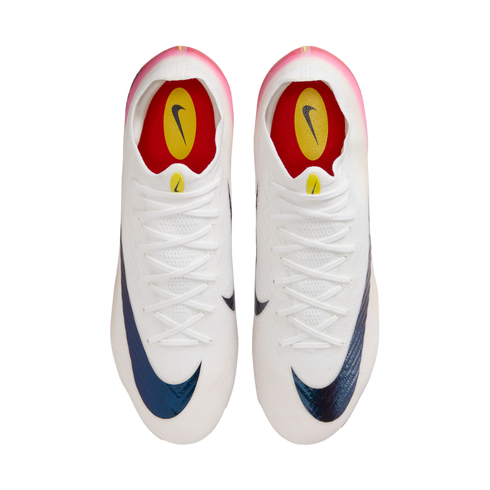 Top-down view of a pair of white Nike soccer cleats featuring iridescent blue swooshes, white laces, and pink heel accents on a plain white background.
