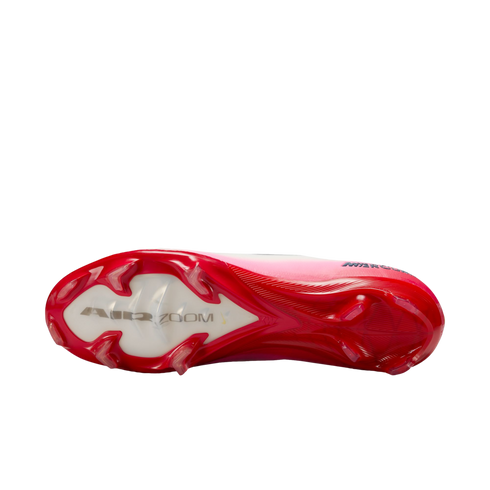 The soleplate of a pink and red Nike Mercurial soccer cleat with "AIR ZOOM" branding and red studs.