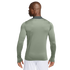 Rear view of a man wearing a sage green long-sleeved athletic shirt with thumbholes and white shorts.