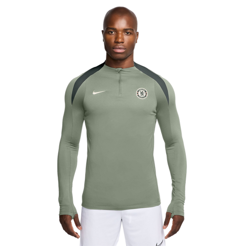 A man models a sage green Nike Chelsea FC quarter-zip training top with dark grey shoulder panels, pictured against a white background.