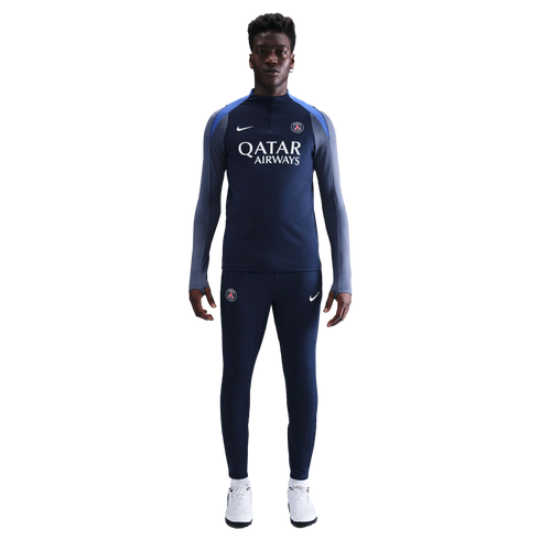 A man wearing a navy blue Nike PSG tracksuit with a Qatar Airways logo stands against a white background.