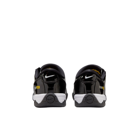 Rear view of black Nike Total 90 III sneakers with white midsoles and yellow branding against a white background.