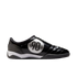 Side profile of a black glossy Nike Total 90 indoor soccer shoe featuring a large silver circular "90" logo and a white midsole.