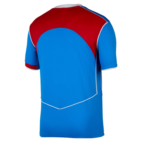 Back view of a blue short-sleeved sports jersey with a red panel across the upper back and white piping details.