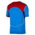 Back view of a blue short-sleeved sports jersey with a red panel across the upper back and white piping details.