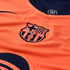 Close-up of a vibrant orange FC Barcelona jersey featuring the club's crest, a navy collar with a "90" logo, and a partial sponsor logo.