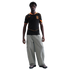 Man wearing a black Nike soccer jersey with orange trim, baggy grey cargo pants, and sneakers, standing against a solid black background.