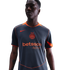 A man wearing a grey and orange Nike Inter Milan soccer jersey with a Betsson.sport logo, looking to the side against a black background.