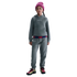 Child in a gray Nike FC Barcelona tracksuit, pink beanie, and colorful sneakers against a black background.