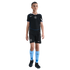 A young boy stands in a black Nike Chelsea FC soccer kit with light blue socks and black cleats, isolated on a black background.