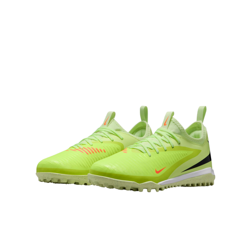Pair of lime green Nike turf soccer shoes featuring orange accents and a speckled white midsole against a black background.
