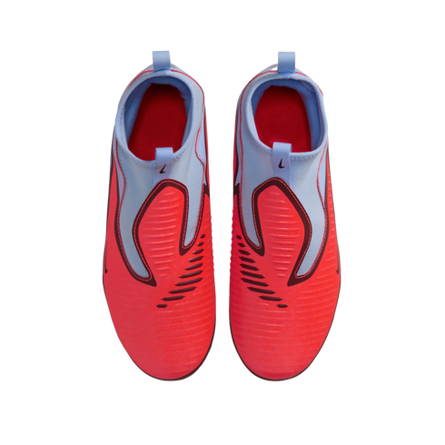Top-down view of vibrant red and light blue Nike laceless soccer cleats on a black background.