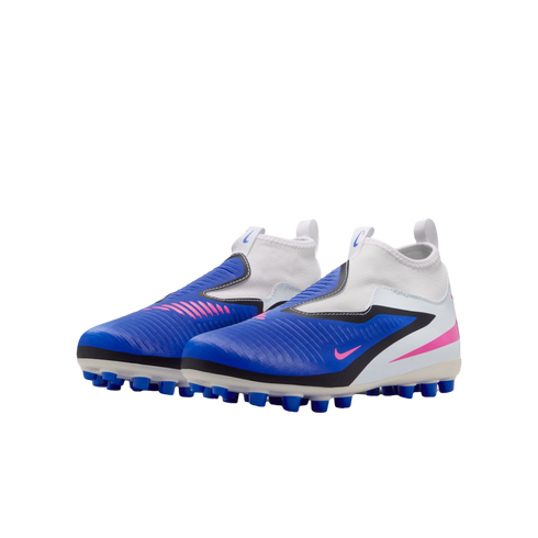 A pair of blue, white, and pink Nike children's laceless soccer cleats shown from a side angle against a black background.
