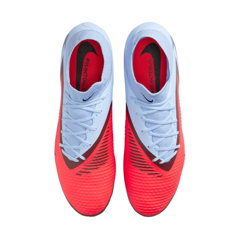 Top-down view of light blue and vibrant red Nike Phantom football boots with white laces, set against a solid black background.