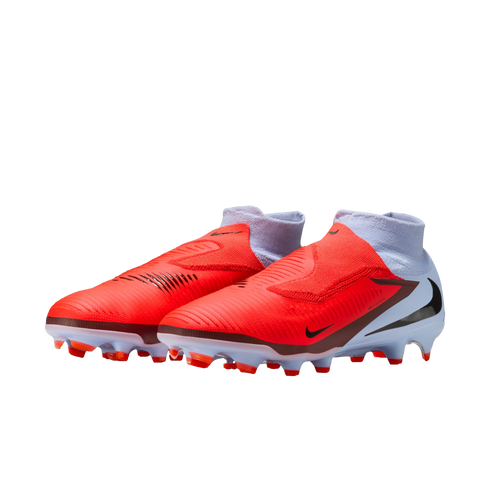 Nike soccer cleats with a bright orange forefoot, white heel, and integrated ankle sock. Features include black swooshes and firm-ground studs, shown against a black background.