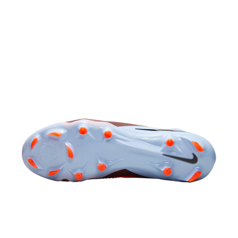 The light blue soleplate of a Nike soccer cleat featuring bright orange studs and a black swoosh on the heel, displayed against a black background.