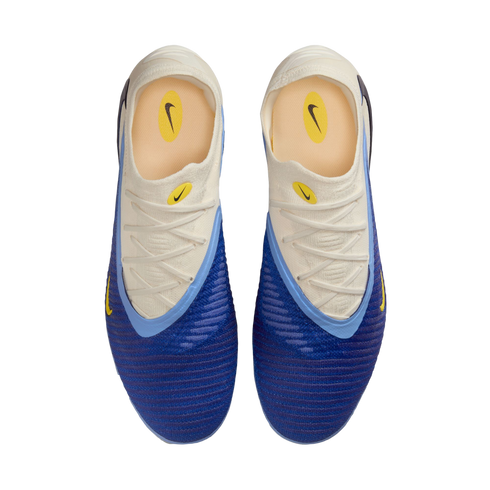 Top-down view of a pair of blue and white Nike soccer cleats with yellow accents and a textured blue forefoot.