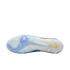 Bottom view of a light blue and white Nike soccer cleat with translucent studs and a small yellow swoosh on the heel.