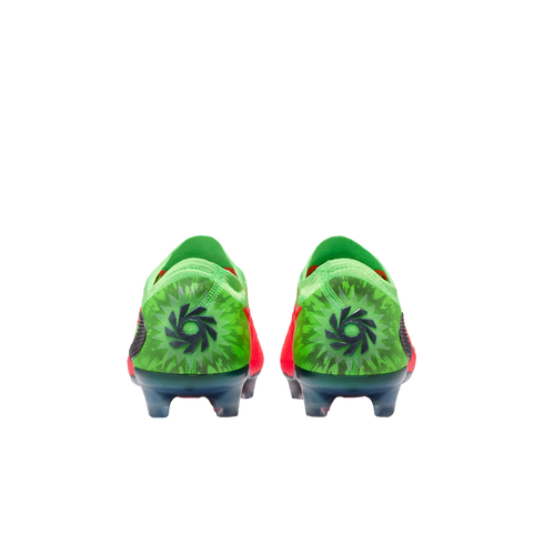 A rear view of a pair of bright green soccer cleats with a black circular logo centered on each heel, featuring a dark green starburst pattern against a solid black background.