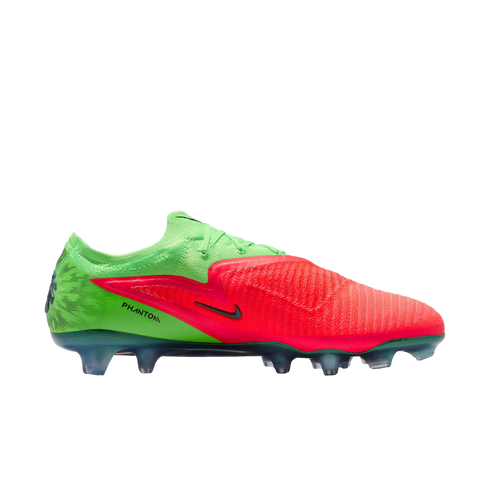 A studio shot of a Nike Phantom soccer cleat against a solid black background. The shoe features a vibrant split color scheme: bright lime green on the heel and collar, and a textured crimson red on the forefoot and midfoot. A small black Nike swoosh and