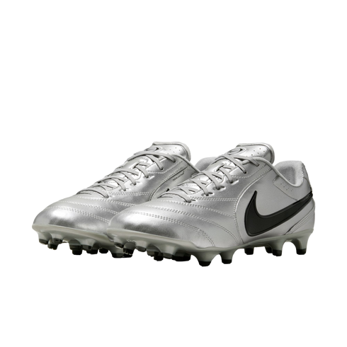 A pair of metallic silver Nike soccer cleats with a black swoosh and grey studs, shown from a three-quarter angle against a black background.