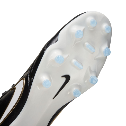 Bottom view of a Nike soccer cleat featuring a white soleplate with light blue studs and a black swoosh logo.