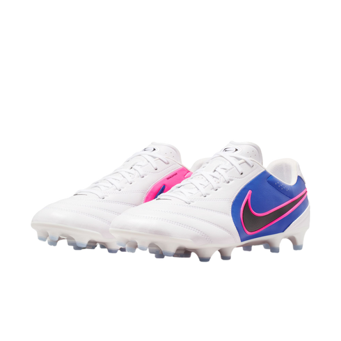 A pair of white Nike soccer cleats with blue heel sections and pink accents, featuring a black swoosh and white studs, against a black background.