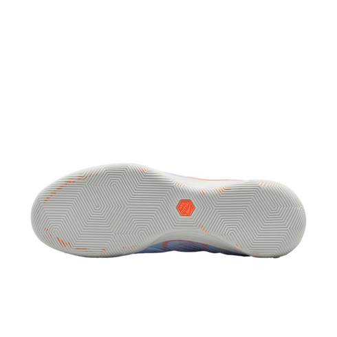 A bottom view of a Nike Futsal shoe showing a light grey rubber outsole with a geometric zig-zag traction pattern and an orange hexagonal logo in the center.