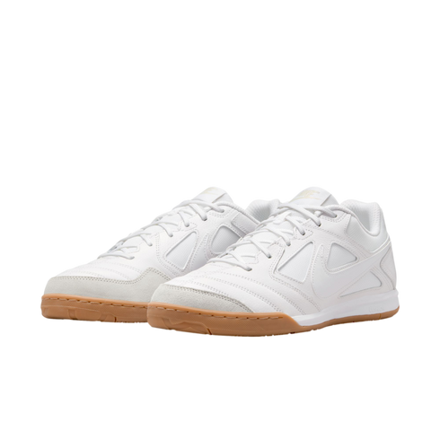 A pair of white Nike sneakers with tan gum soles and white laces, shown from a three-quarter angle against a solid black background.