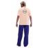 Back view of a man wearing a peach-colored Nike Barça t-shirt and baggy blue pants against a black background.