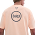 Back view of a person wearing a light orange Nike t-shirt with a large circular "BARÇA" graphic on the back against a black background.