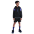 A young boy wearing a black and purple hoodie, black shorts, and purple socks stands against a solid black background.
