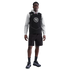 A Black man in a gray hoodie, black Nike jersey with "90" logo, black cargo shorts, and sneakers, standing against a solid black background.
